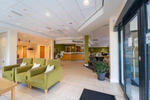 a lobby with green chairs and a pharmacy at Ramsey Park Hotel in Ramsey