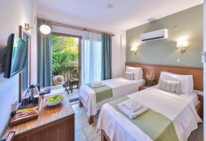 ein Hotelzimmer mit zwei Betten und einem Fernseher in der Unterkunft Medusa Hotel in Kaş