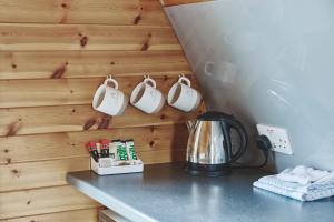 a kitchen counter with mugs hanging on a wall at Iona Pods in Iona