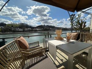 a table and chairs on a deck with a view of the water at Schloß Ort in Passau