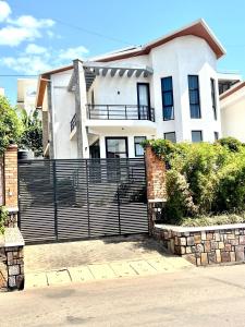a white house with a fence in front of it at KiGALI NORMAL VIEW APARTMENT in Kigali