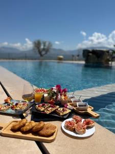 a table with food and wine next to a swimming pool at Vila Marjana in Sarandë