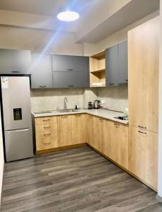 a kitchen with wooden cabinets and a white refrigerator at Forest view Tsaghkadzor in Tsaghkadzor