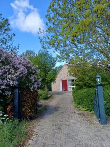 a brick driveway leading to a red garage at B & B it Heech in Ferwerd +7 photos