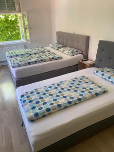 a room with three beds with blue and white covers at Gästehaus Jasmin in Lindau