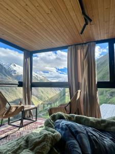 a bedroom with a large window with a view of mountains at Pirdapira in Jut'a
