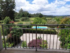 a balcony with a view of a garden and a pool at CASA Arce in Boqueijón