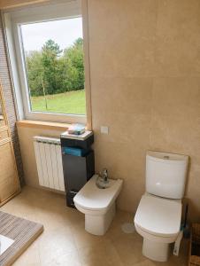 a bathroom with a toilet and a window at CASA Arce in Boqueijón +13 photos