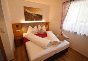 a bedroom with a bed with white sheets and pillows at Residenz Erschbaum in Valdaora +91 photos