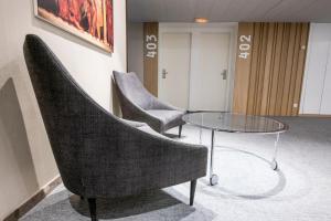 a meeting room with two chairs and a glass table at Silken Ramblas in Barcelona