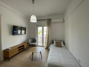 a small room with a bed and a table and a couch at MyLiving in Kardamaina