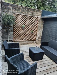 a patio with chairs and a bench and a table at 2 Pause détente avec terrasse privée in Ernée