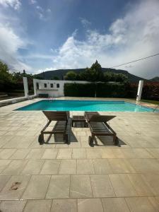 a picnic table and bench next to a swimming pool at Coastal Pool Hideaway in Loukísia