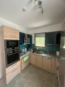 a kitchen with wooden cabinets and a stove top oven at Coastal Pool Hideaway in Loukísia