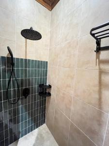 a bathroom with a shower with green and black tiles at Wavedance Bali Surfhouse in Airsatang +19 photos