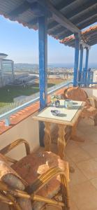 a table and chairs on a balcony with a view at Hill View in Nikiti
