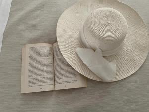 a hat and a book on a table with a napkin at Le 2 vele in Cerfignano