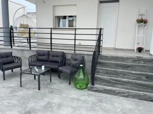 a green vase sitting next to two chairs and a table at Le 2 vele in Cerfignano