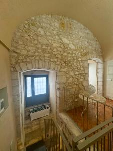 a room with a stone wall with a sink and a window at MaryClouBert-Home in Molfetta
