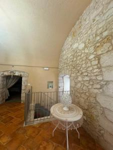 a room with a table and a stone wall at MaryClouBert-Home in Molfetta