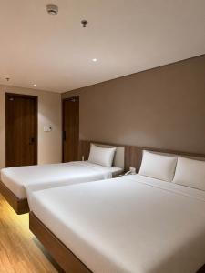 two beds in a hotel room with white sheets at Thanh Bình Hotel - Buôn Ma Thuột in Buon Ma Thuot +83 photos