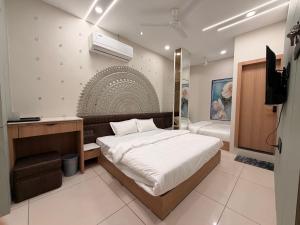 a bedroom with a bed and a television in it at Hotel Shree Maya Comfort Inn in Ujjain