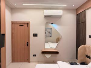 a bathroom with a mirror next to a bed at Hotel Shree Maya Comfort Inn in Ujjain