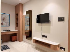 a room with a tv on a wall with at Hotel Shree Maya Comfort Inn in Ujjain +44 photos