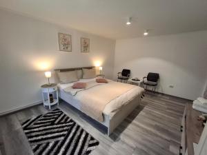a bedroom with a bed with two chairs and two lamps at Apartament Claudia in Deva