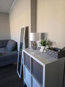 a living room with a table with a lamp and a couch at Küti apartments in Rakvere +1 photo