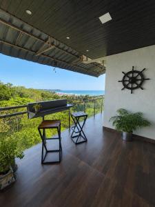 a room with a piano and a view of the ocean at Neelaashray Sea view apartment in Ratnagiri