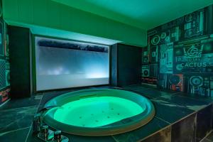 eine grüne Badewanne in einem Zimmer mit Fernseher in der Unterkunft HOTEL the CACTUS in Kasugai