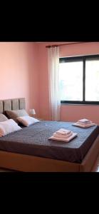 a bedroom with two towels on a bed with a window at Room 357 in Tirana