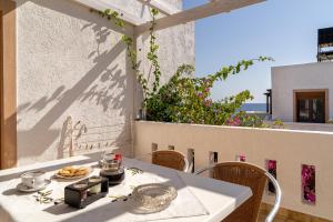 a white table with a plate of food on a balcony at Akrotiri Apartments in Makry Gialos