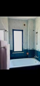 a white bath tub in a bathroom with a window at Room 357 in Tirana