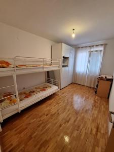 a room with two bunk beds and a wooden floor at Stan Foča in Foča