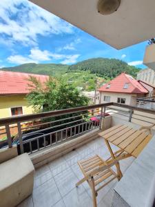a balcony with a wooden bench and a table at Stan Foča in Foča