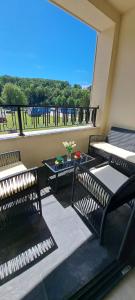 a balcony with two chairs and a large window at Apartman Kristal, Vrnjačka Banja in Vrnjci