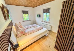 a small room with a bed and two windows at Seebühnenblick in Seeham