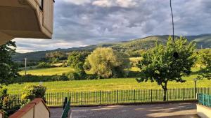a view of a field with a fence and trees at Casa Bibi in Subbiano