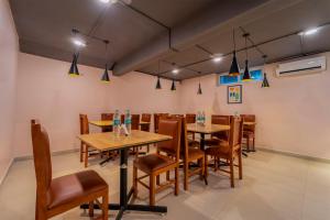 a dining room with tables and chairs and lights at Treebo Premium Lavender Kochi Infopark in Cochin