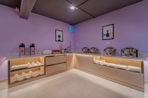 a room with purple walls and a counter with dishes at Treebo Premium Lavender Kochi Infopark in Cochin
