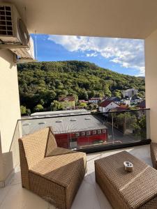 a balcony with two chairs and a view of a building at Apartament Căciulata Duo cu 2 camere independente in Căciulata