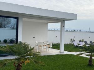a white house with a table and chairs at Sunrise Villa in Rrushkull
