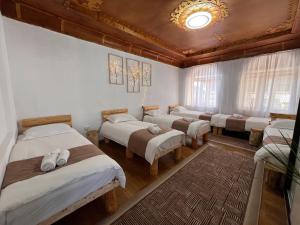 a row of beds in a room with a ceiling at Crown Inn & Spa in Karakol