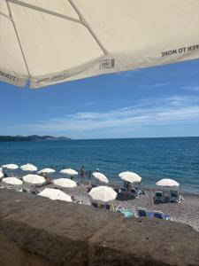 a group of umbrellas and chairs on a beach at Apartman Katarina in Sutomore