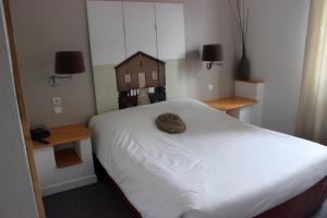 a bedroom with a bed with a small house on it at A la Maison Rouge Hôtel & Restaurant in Barr