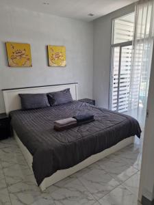 a bedroom with a large bed with a black comforter at Eid and Philippe's Home building A9 in Ban Ko Kwang +16 photos