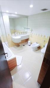 a bathroom with two toilets and a tub and a sink at فندق دولف in Al Khobar
