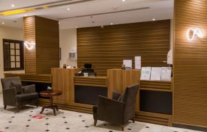 a hotel lobby with a reception desk and chairs at فندق دولف in Al Khobar